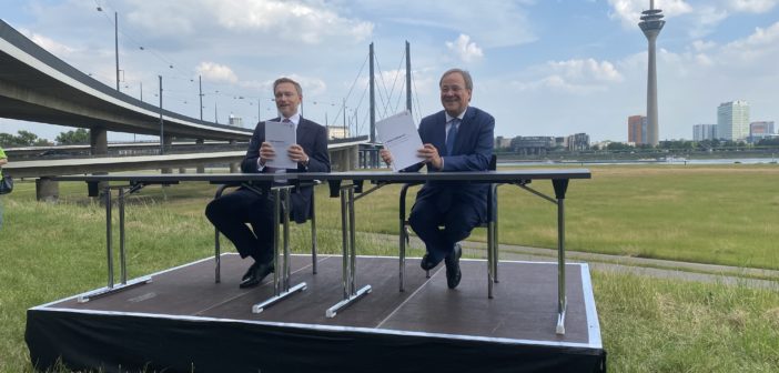 Christian Lindner (links) und Armin Lasdchet halten Koalitionsvertrag in die Kamera